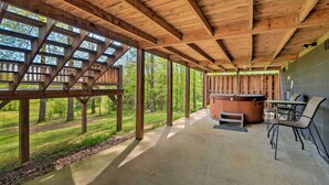 A covered outdoor area with a hot tub, seating, and a view of a forested area. - Cozy Trenton Cabin w/ Spa ~ 15 Mi to Lookout Mtn! (Trenton)