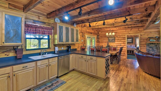 A log cabin interior with a kitchen, dining area, and a fireplace. - Cozy Trenton Cabin w/ Spa ~ 15 Mi to Lookout Mtn! (Trenton)