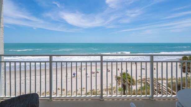 Ein Balkon mit Blick auf den Strand und das Meer.