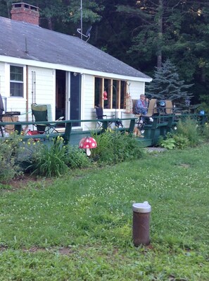 Relax on the porch with a charming view of lush greenery.