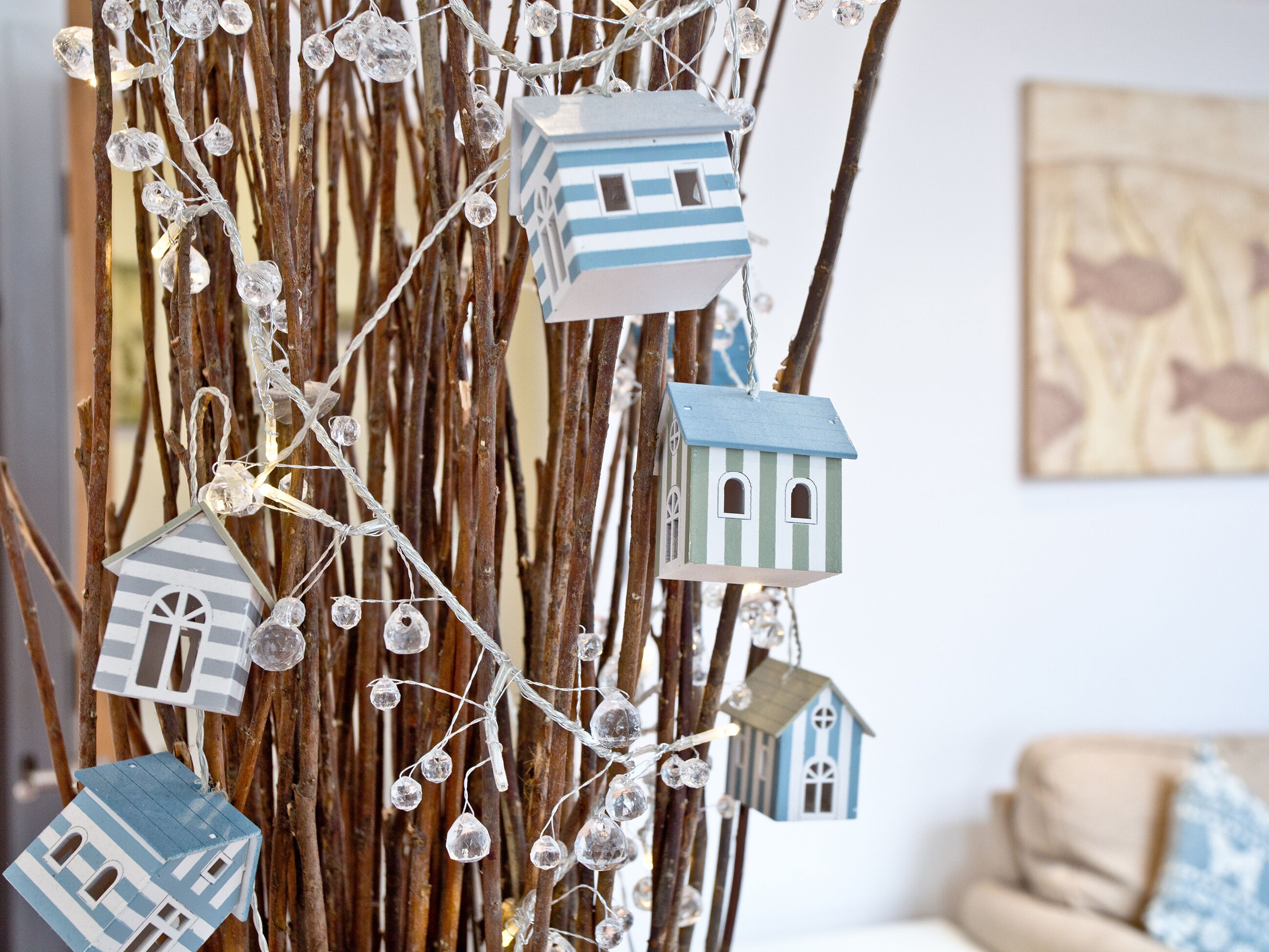 A decorative tree with hanging birdhouses and string lights.