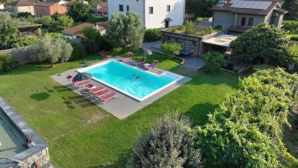 A residential area with a swimming pool surrounded by grass, trees, and houses. - Refined and welcoming Villa with private pool surrounded by nature (Omignano Scalo)
