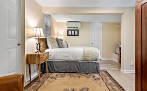 Une chambre à coucher avec un lit, une table de chevet, une lampe et un tapis à motifs.
