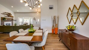 A modern dining area with a wooden table, cushioned chairs, and a decorative centerpiece. - New Roadrunner heights (Joshua Tree)