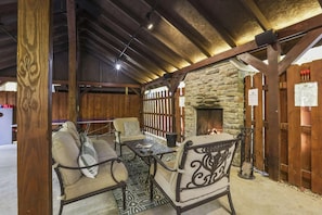 A cozy seating area with a stone fireplace, wooden beams, and a rustic ambiance. - Total Privacy, Plus fun: Hot tub, pool table (Rockbridge)