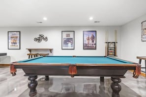 A pool table in a room with framed movie posters on the wall and a pool cue rack. - Total Privacy, Plus fun: Hot tub, pool table (Rockbridge)