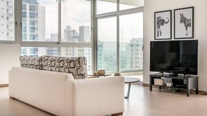 Una sala moderna con un sofá, un televisor y obras de arte en la pared.