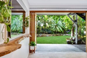 A modern interior with a view of a lush garden. - Sandy Toes and Salty Kisses - Sunshine Coast (Marcoola)