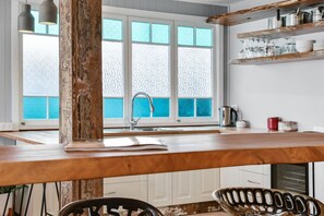 Una cucina con un'ampia finestra, un piano di lavoro in legno e un lavello.