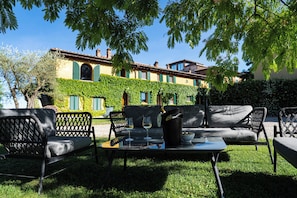 An outdoor seating area with a table, chairs, and a bottle of champagne.