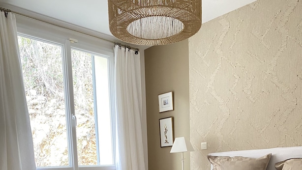 A bedroom with a large bed, a bench, a bedside table, and a window with curtains. - Avignon Lovely Flat (Villeneuve-lès-Avignon)