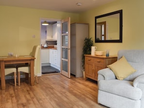 Un espace de vie compact comprenant un coin repas, une kitchenette et un coin salon.