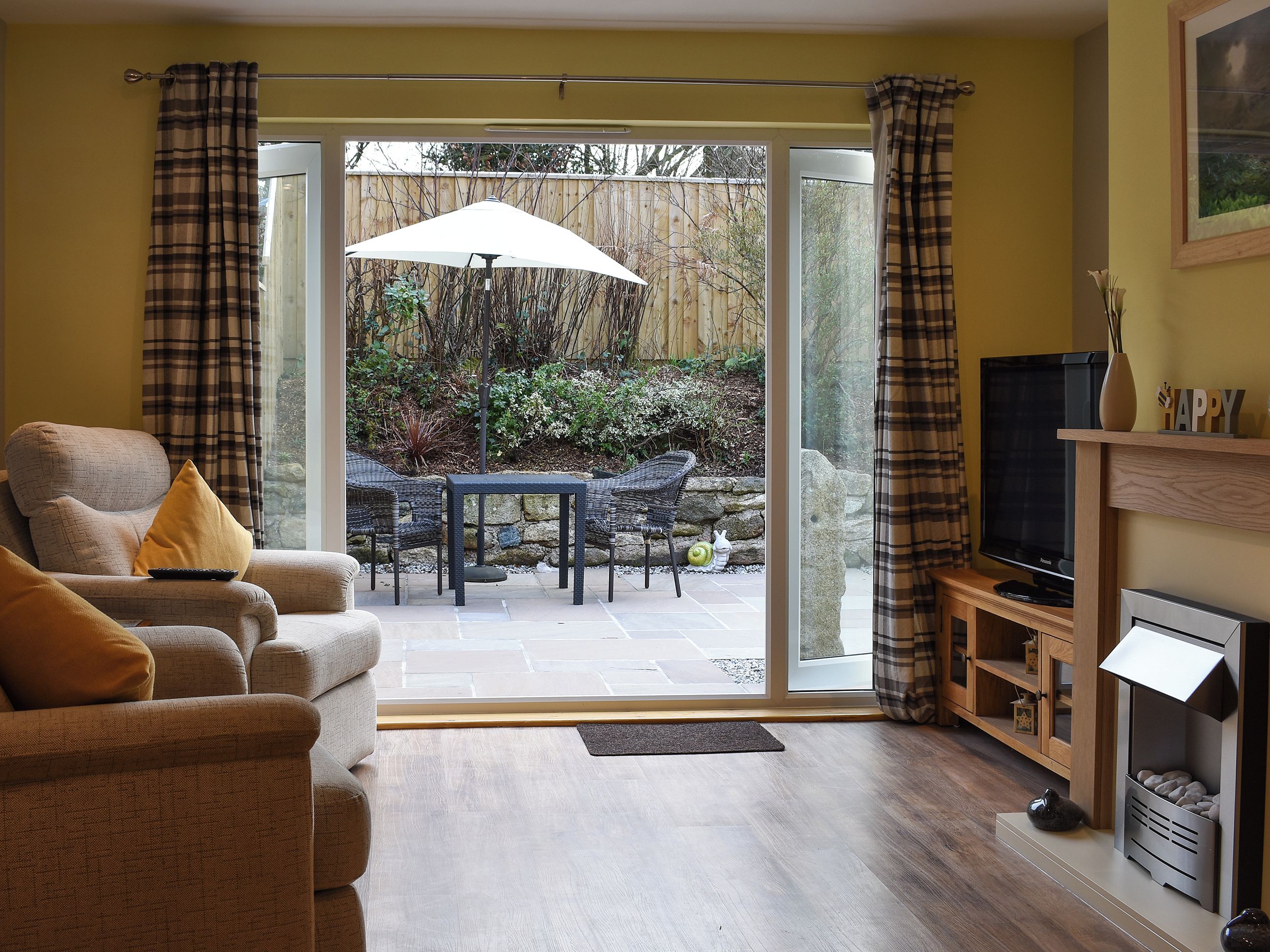 A living room with a sofa, a television, and a dining area with a table and chairs.