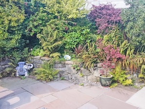A garden with a variety of plants and a decorative ceramic pot.