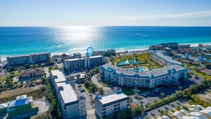 Complejo hotelero frente al mar con varias edificaciones y una piscina central.