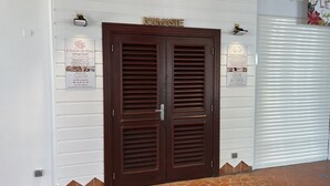 Una puerta doble de madera con un letrero que dice "NAMASTE" encima.