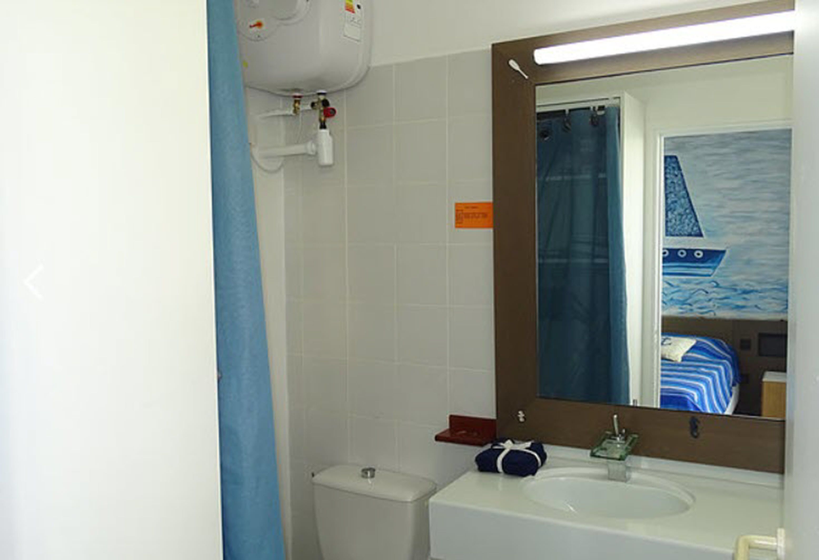A bathroom with a white sink, a mirror, and a toilet.