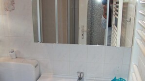 Un bagno con un lavandino bianco, un water e uno specchio sopra il lavandino.