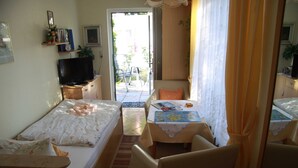 Una camera da letto con un letto, una TV, una scrivania con una sedia e un tavolino con una sedia.