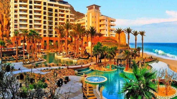 A resort with multiple swimming pools, palm trees, and a beach. - LUXURIOUS PRESIDENTIAL suite 2 bedroom 3 baths (Cabo San Lucas)