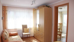 A bedroom with a bed, a wardrobe, a chair, and a radiator. - Vacation apartment 1 - Ferienanlage Bräuning (Binz)