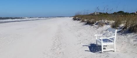 Ranta lähistöllä, aurinkotuoleja, rantapyyhkeitä