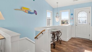 A room with a staircase, a white door with a glass window, and a view of the outdoors. - Sandy Bottoms: Oceanside, Pool, Spa, Dogs OK (Nags Head)