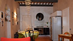 Una cocina compacta con comedor, refrigerador y una araña.