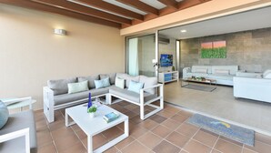 A modern living room with a sofa, coffee table, and a dining area. - Par 4 Rental 9 Salobre by VillaGranCanaria (Maspalomas)