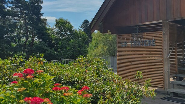 Un edificio in legno con tetto spiovente e un cartello con scritto "Hotel Tannberg".