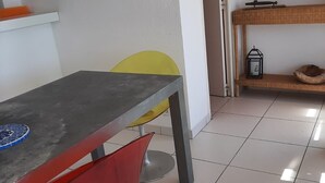 Ruokailutila, jossa on pöytä, tuoleja ja laatoitettu lattia.