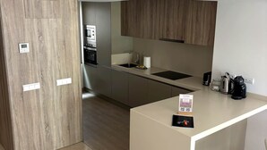 Una cocina moderna con una isla central, electrodomésticos integrados y una pared de acento de madera.