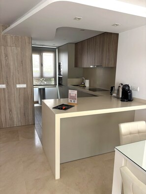 A modern kitchen with a central island, built-in appliances, and a view to the outdoors.