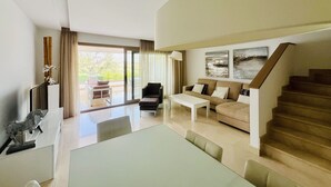 Amplia sala de estar con sofá, mesa de centro y escalera.