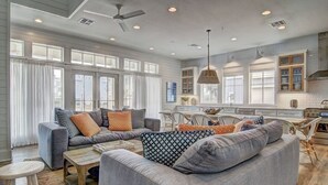A spacious living room with a grey sectional sofa, a coffee table, and a dining area with a white table and chairs. - Cinnamon Shore Home Near Beach w/ Access to Resort-Like Amenities! (Port Aransas)