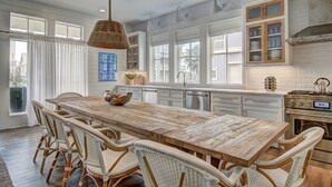 A spacious kitchen with a large island, white cabinetry, and a hanging light fixture. - Cinnamon Shore Home Near Beach w/ Access to Resort-Like Amenities! (Port Aransas)