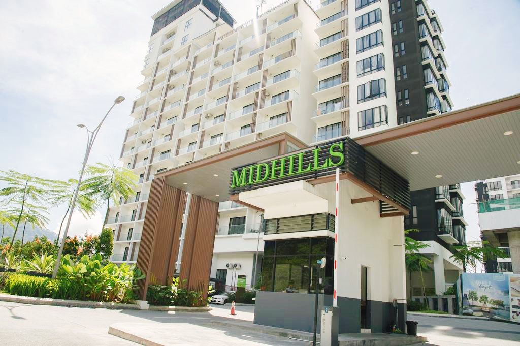 A modern hotel entrance with a prominent sign reading "MIDHILLS."
