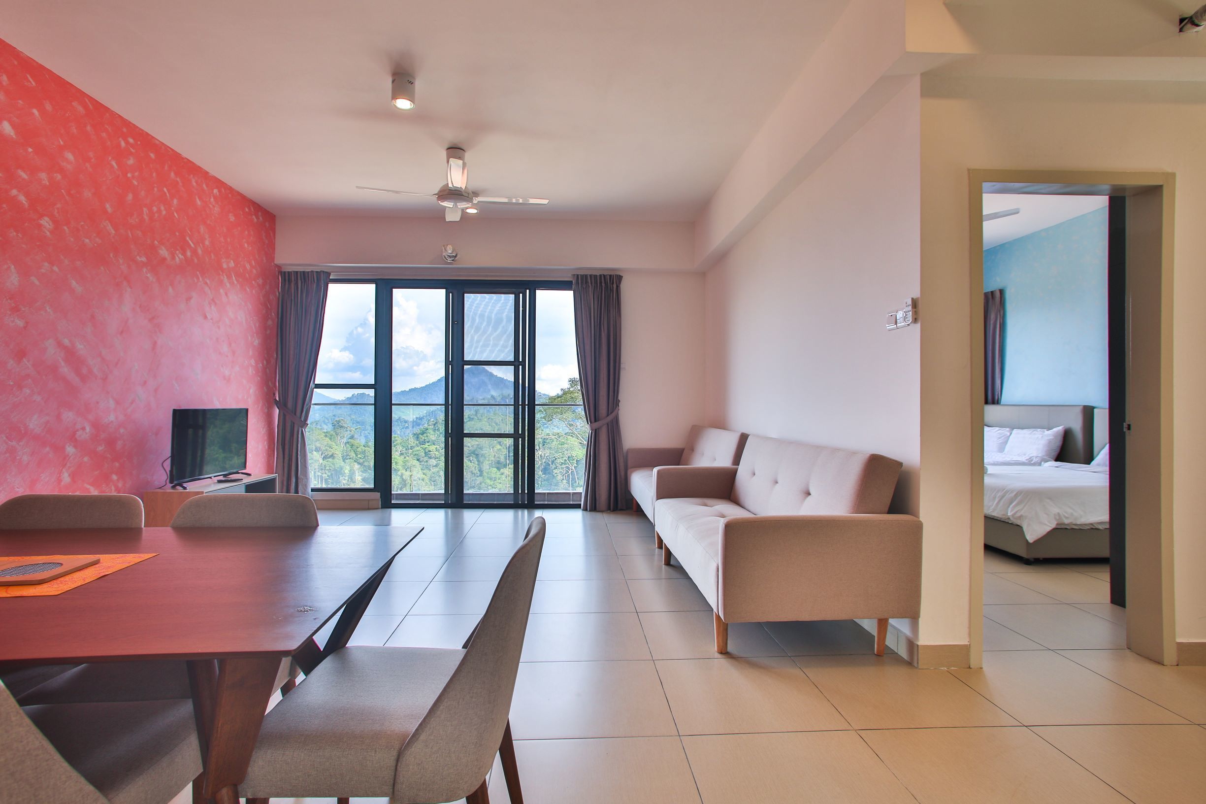 A modern hotel room with a dining area, a sofa, and a bed.