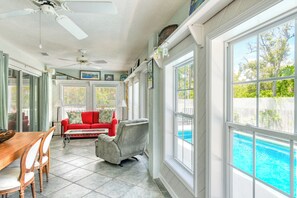 A sunlit room with a pool, a ceiling fan, and a dining area. - Seahorse - Beautiful Beach House with Private Pool & Heated Spa! (Butler Beach)