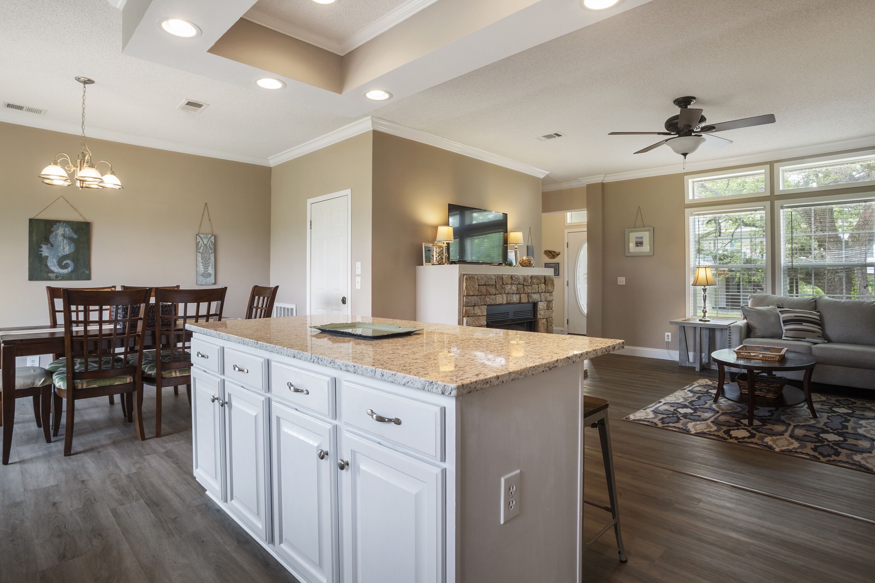 A spacious kitchen with a large island, wooden dining set, and a fireplace.