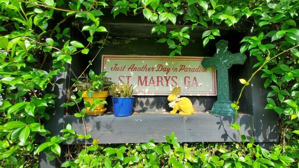 Un panneau vert avec une croix et les inscriptions « Encore une journée au paradis » et « St. Mary's, Géorgie ».