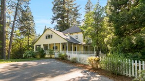 A two-story house with a porch, surrounded by tall trees and a white picket fence. - PERFECT FAMILY GETAWAY! Historic CRYSTAL SPRINGS INN is all yours - 4,000 sq ft! (ALTA)