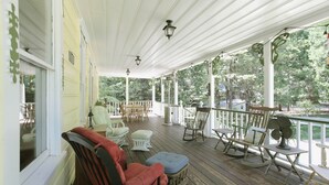 A covered porch with wooden flooring, white railings, and outdoor furniture including rocking chairs and ottomans. - PERFECT FAMILY GETAWAY! Historic CRYSTAL SPRINGS INN is all yours - 4,000 sq ft! (ALTA)