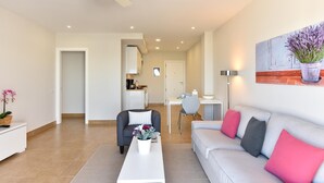 Un salon moderne comprenant un canapé, une table basse et un coin repas avec une table et des chaises.