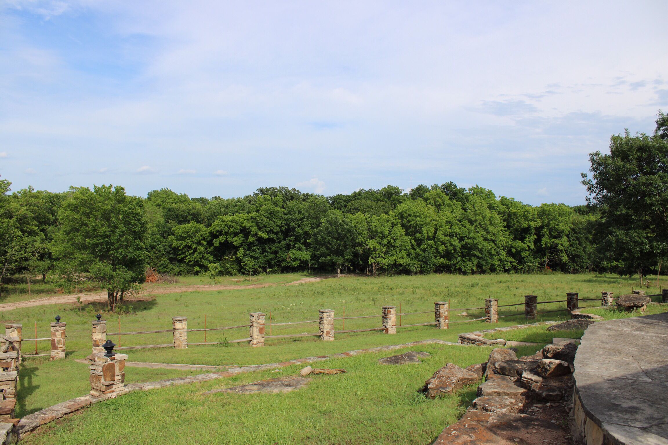 Un sitio arqueológico con ruinas de piedra y un campo cubierto de hierba.