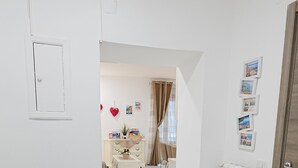 A hallway with a white door, a radiator, and a small table with a plant. - Apartment in the heart of the Spanish Quarter, next to Via Toledo. (Napoli)