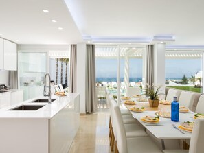 Enjoy meals in the kitchen with a dining area adjacent, offering a view of the pool and outdoor seating.