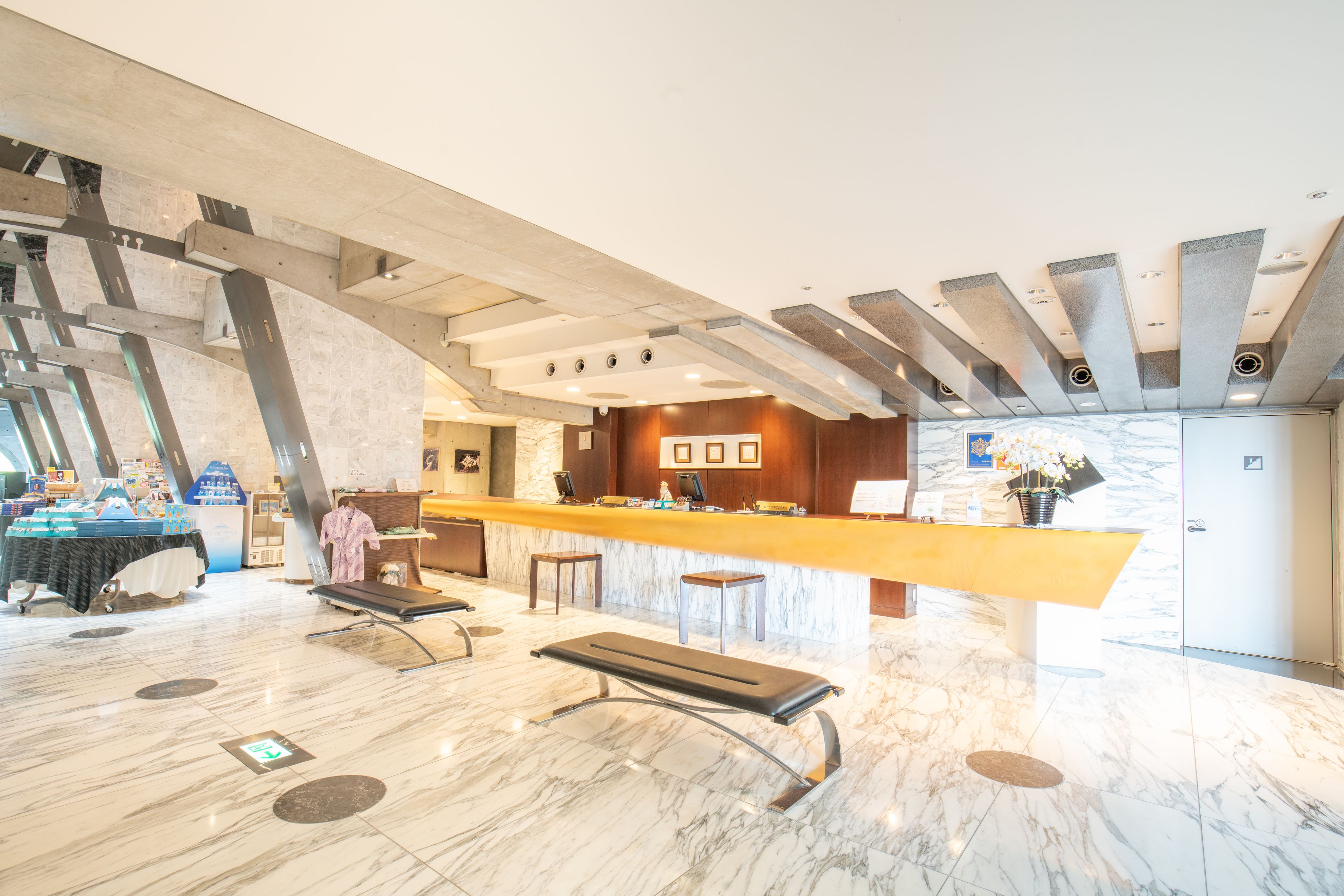 A spacious lobby with a marble floor, a reception desk, and a seating area.