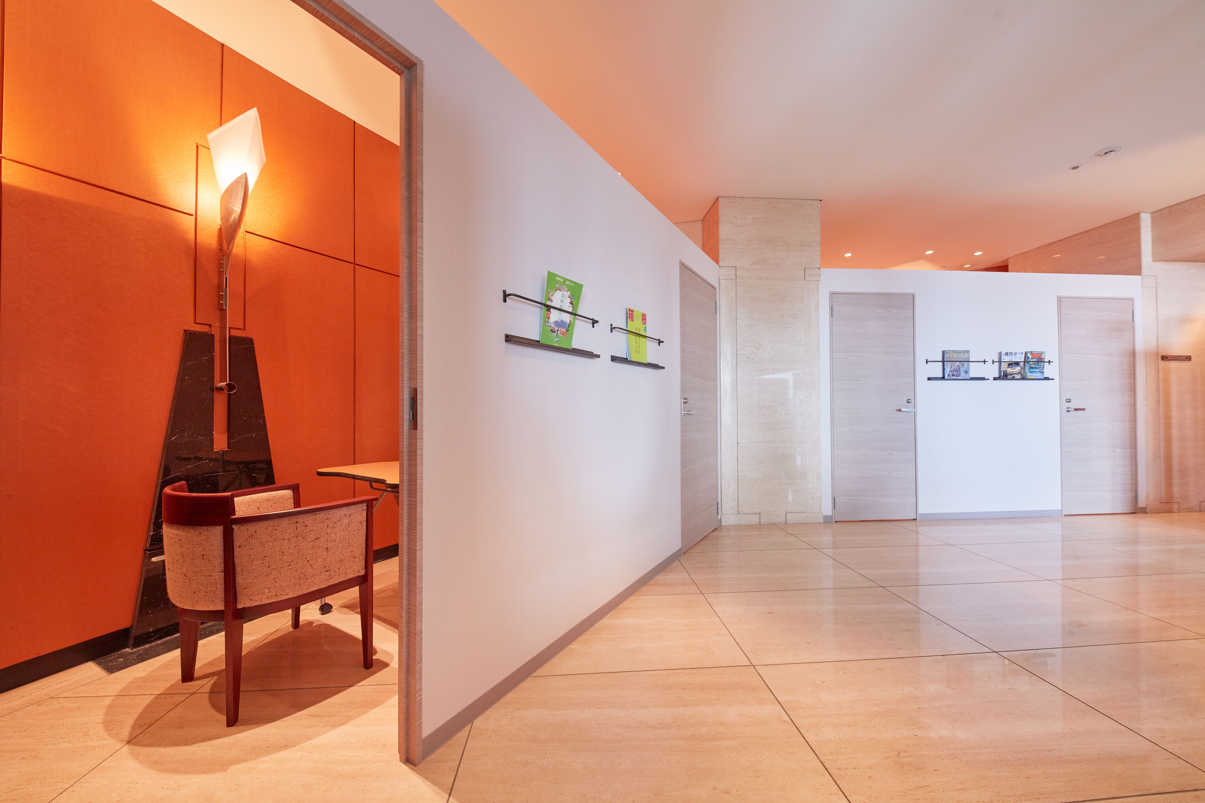 Un moderno vestíbulo de hotel con zona de estar, mostrador de recepción y piso de baldosas limpias.