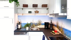 A kitchen with a view of the sea, a Siemens dishwasher, a coffee maker, and a sink. - *Anker Vacation Rental at Villa Victoria - GM 69836 - *Anker Vacation Rental at Villa Victoria (Graal-Müritz)
